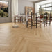 Canadian Standard Akita 12mm waterproof laminate flooring arranged in a classic herringbone pattern with realistic textured wood grain applied in a dining room