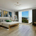 Canadian Standard EGGER PRO Light Nakina Oak 12mm laminate flooring featuring 7.6-inch wide planks with natural oak-look wood grain applied in a bedroom