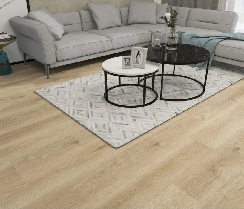 Canadian Standard Nikko Elemental12 waterproof laminate flooring featuring wide 9.29-inch wood-look planks with realistic grain and textured finish in a living room