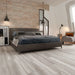 Canadian Standard Inhaus Inspiration Lamdura Oak Light Grey 8mm water-resistant laminate flooring featuring light grey oak-look wood grain in a bedroom