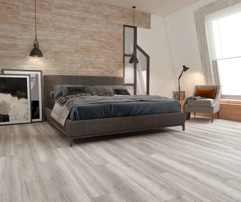 Canadian Standard Inhaus Inspiration Lamdura Oak Light Grey 8mm water-resistant laminate flooring featuring light grey oak-look wood grain in a bedroom