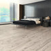 Canadian Standard Inhaus Inspiration Lamdura Sedgwick 8mm water-resistant laminate flooring with 7.56-inch-wide wood-look planks and realistic grain in a bedroom