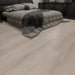 NAF Silver Dune 14mm waterproof laminate flooring featuring 7.7-inch wood-look planks with a realistic 4D textured finish in a bedroom
